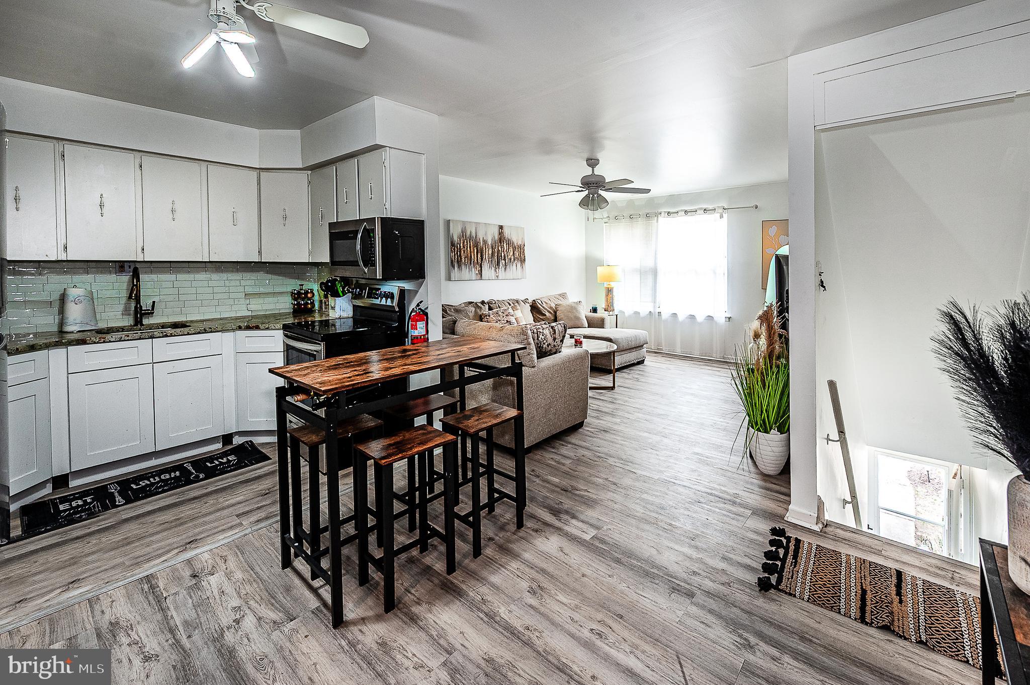 808 Winding Way Westville, NJ 08093 - Photo 6 of 14 a kitchen with stainless steel appliances a dining table chairs stove a refrigerator and cabinets