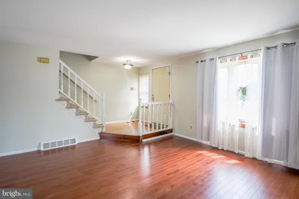 a view of a livingroom with wooden floor and stairs
