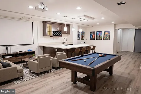 a room with furniture pool table flat screen tv and couches