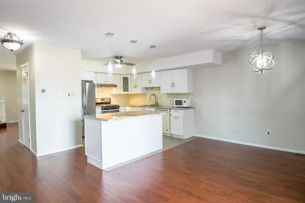 a view of kitchen with cabinets appliances and wooden floor