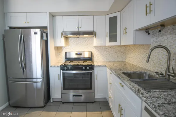 a kitchen with granite countertop stainless steel appliances and a counter space