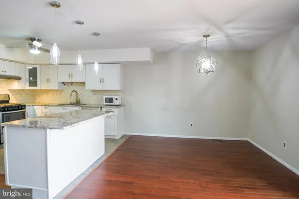 a kitchen with granite countertop a sink cabinets and wooden floor