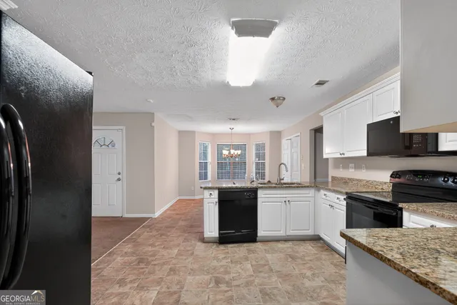 a kitchen with stainless steel appliances granite countertop a refrigerator a stove a sink and a microwave