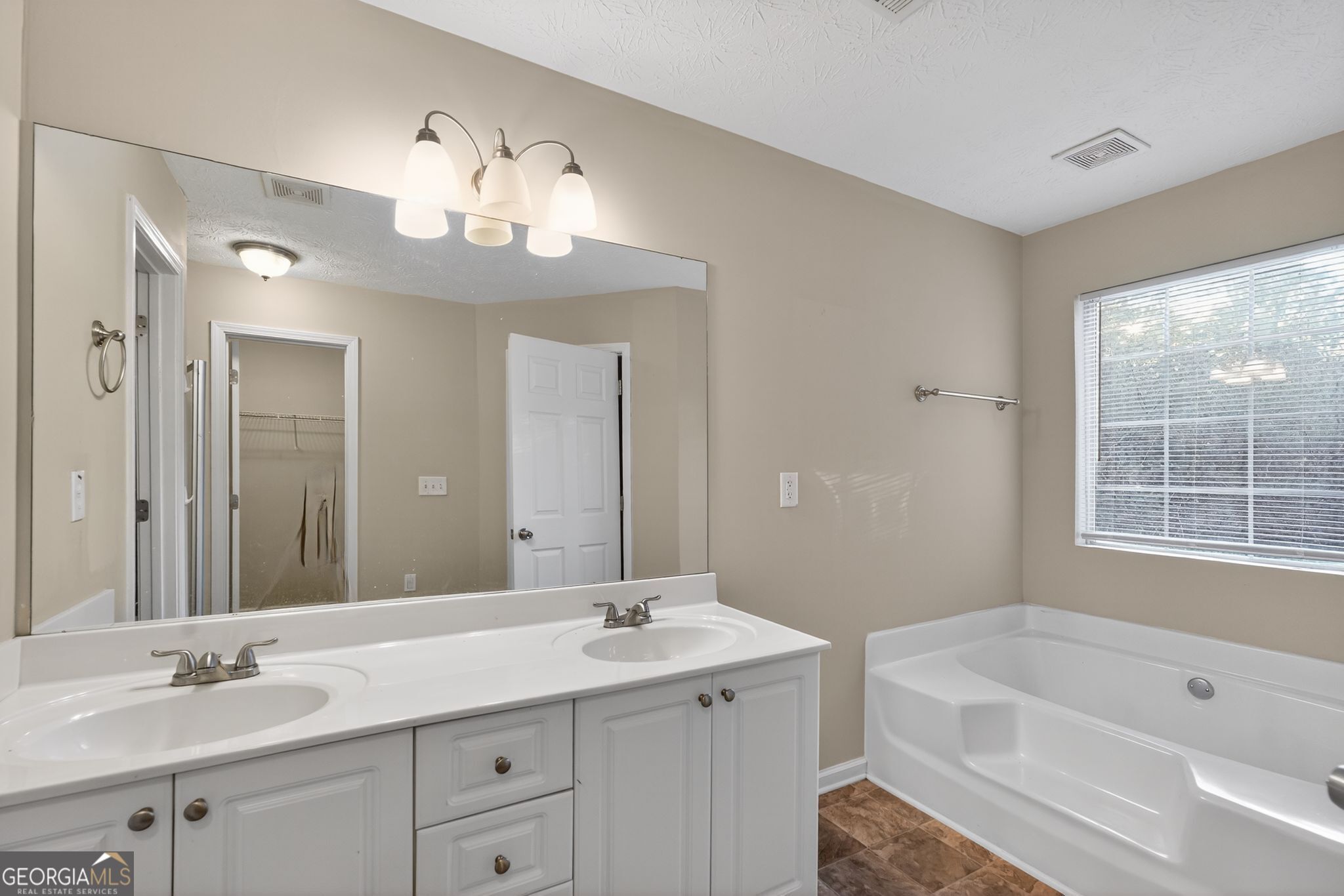 6463 Castle Ct Way Lithonia, GA 30058 - Photo 22 of 35 a bathroom with a tub a sink double vanity and a mirror