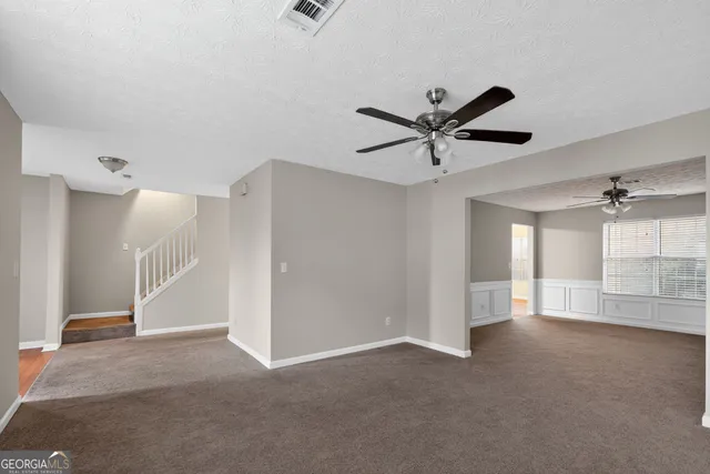 a view of an empty room with a ceiling fan