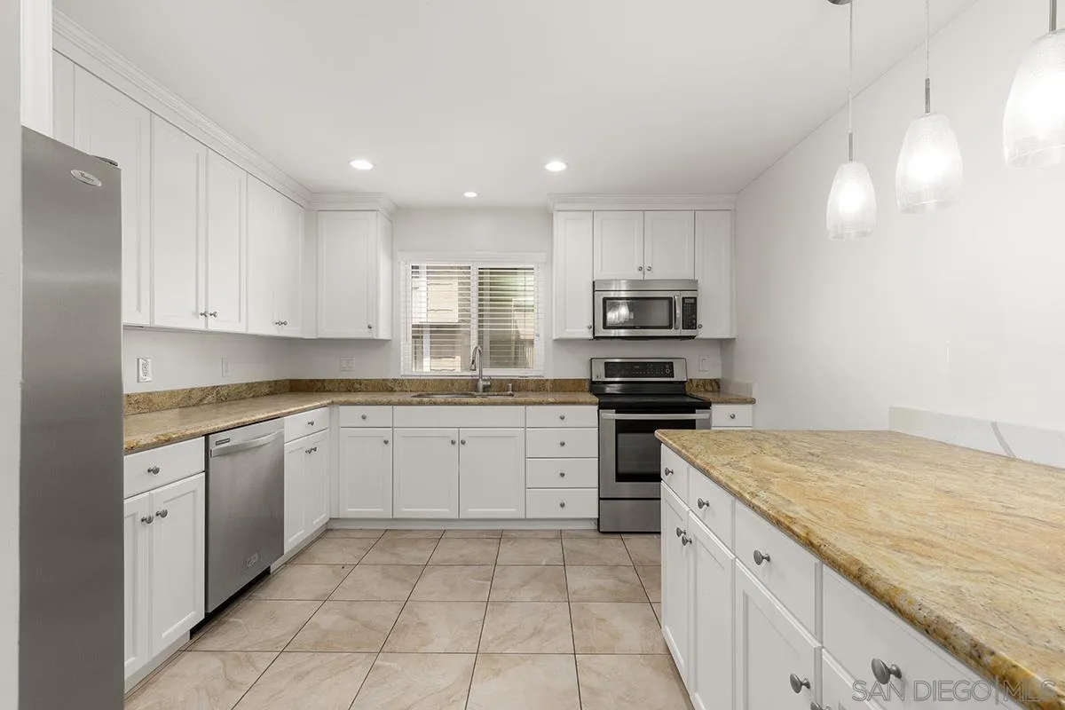 4028 Mahaila Avenue, Unit C San Diego, CA 92122 - Photo 14 of 34 a kitchen with granite countertop a sink and white cabinets