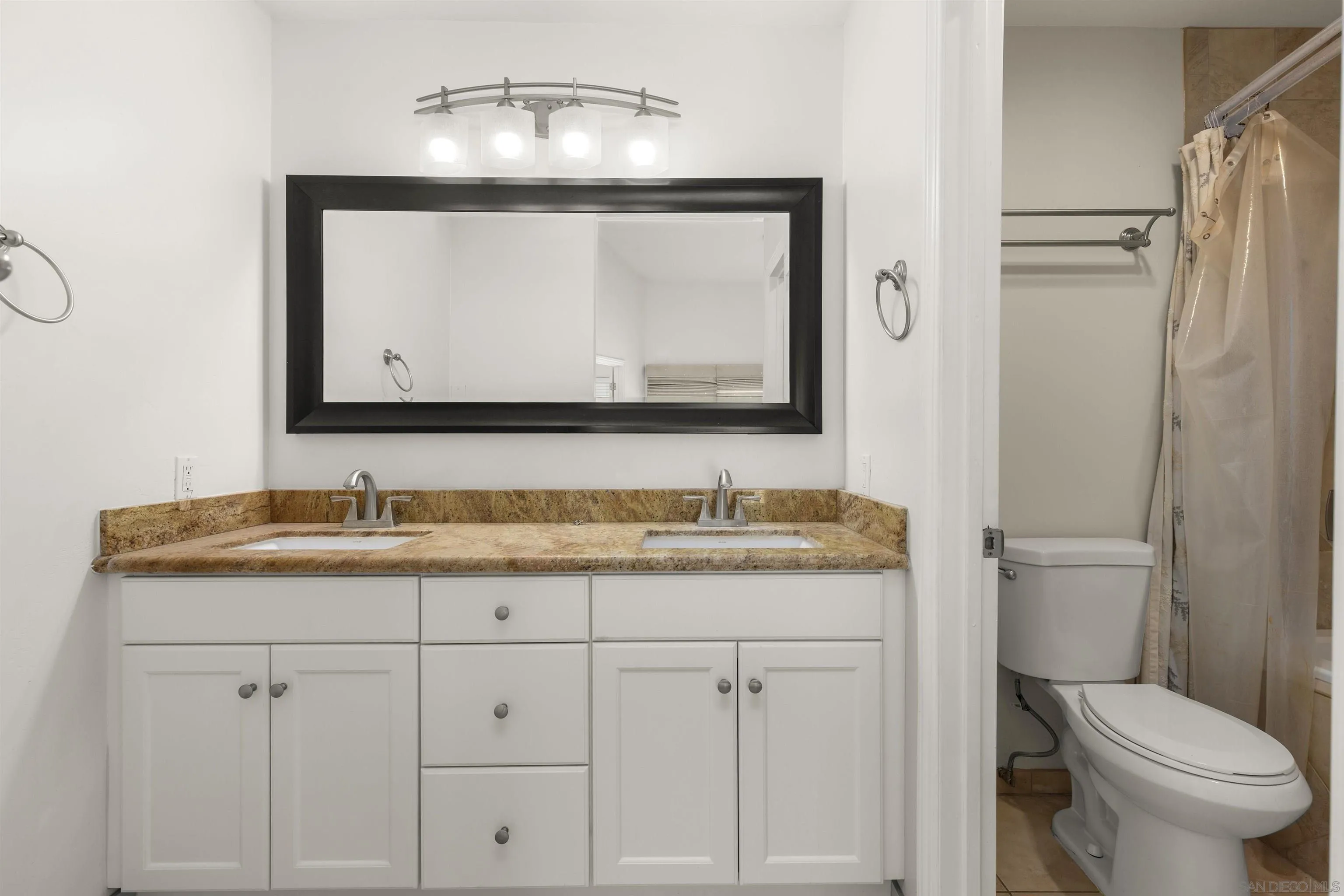 4028 Mahaila Avenue, Unit C San Diego, CA 92122 - Photo 22 of 34 a bathroom with a granite countertop toilet sink and mirror