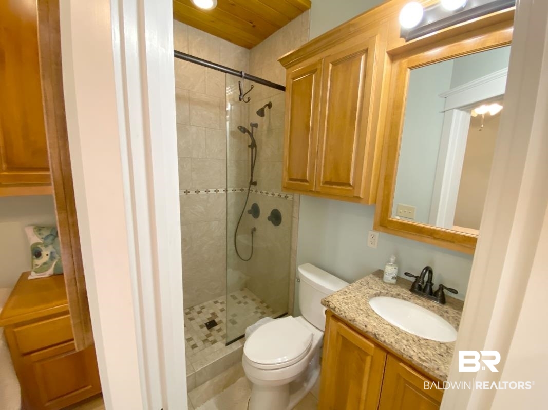 28888 Canal Road, Unit 71 Orange Beach, AL 36561 - Photo 7 of 9 Bathroom with vanity, toilet, and tiled shower