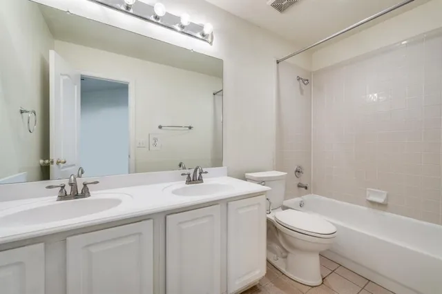 a bathroom with a toilet a sink a tub and mirror