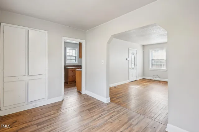 an empty room with wooden floor and closet