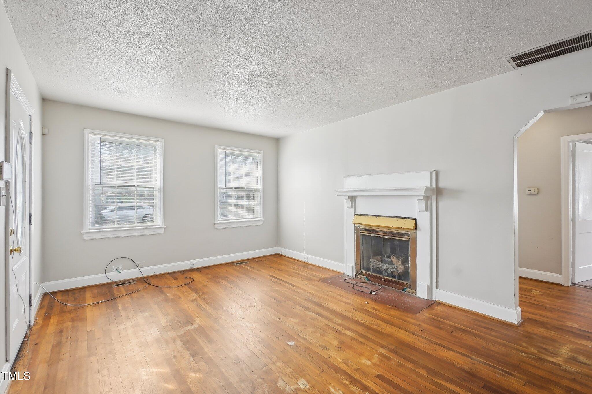 115 Higbee Street Durham, NC 27704 - Photo 4 of 14 wooden floor fireplace and natural light in room