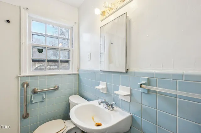 a bathroom with a toilet a sink and mirror