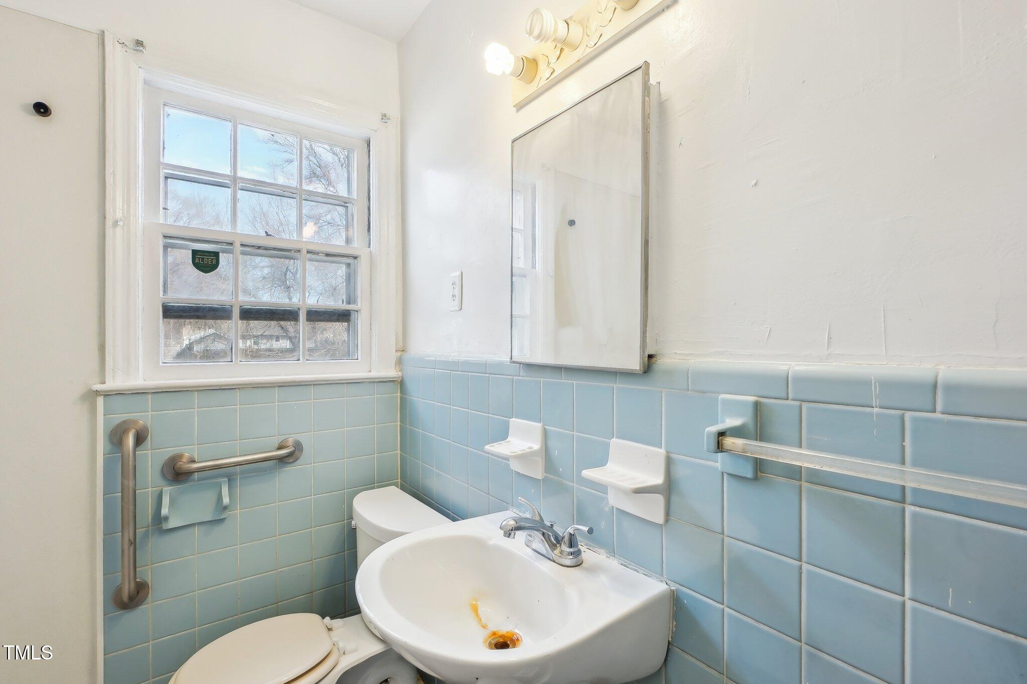 115 Higbee Street Durham, NC 27704 - Photo 6 of 14 a bathroom with a toilet a sink and mirror