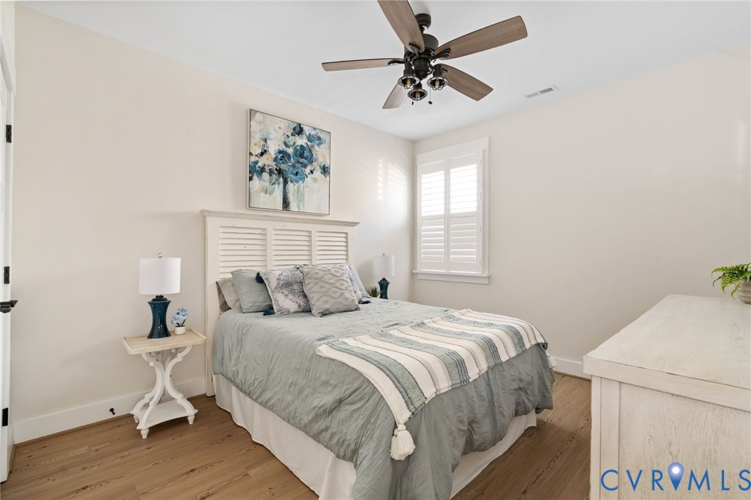 8614 Terroir Lane New Kent, VA 23124 - Photo 26 of 42 a bedroom with a bed and a chandelier