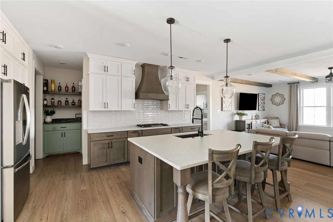 8614 Terroir Lane New Kent, VA 23124 - Photo 6 of 42 a kitchen with stainless steel appliances kitchen island granite countertop a dining table chairs and white cabinets