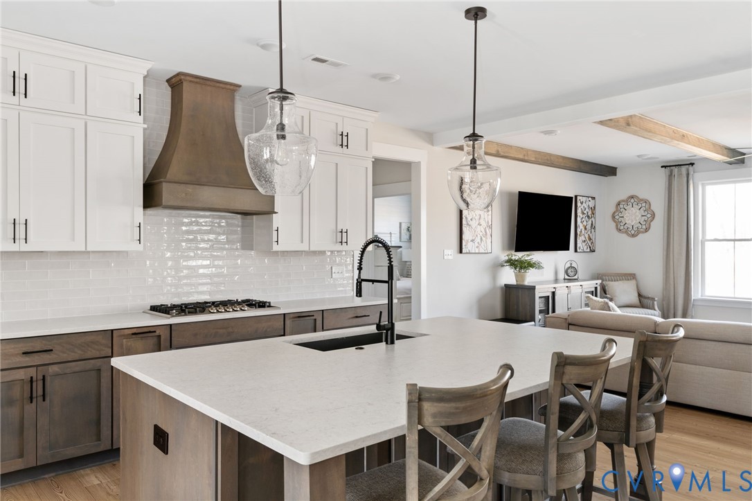 8614 Terroir Lane New Kent, VA 23124 - Photo 7 of 42 a kitchen with stainless steel appliances granite countertop a stove a sink a microwave a refrigerator a dining table with chairs and white cabinets