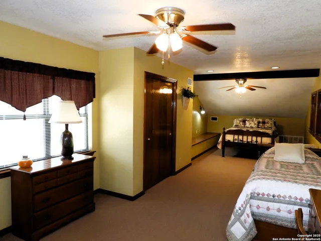 a bedroom with furniture and a mirror