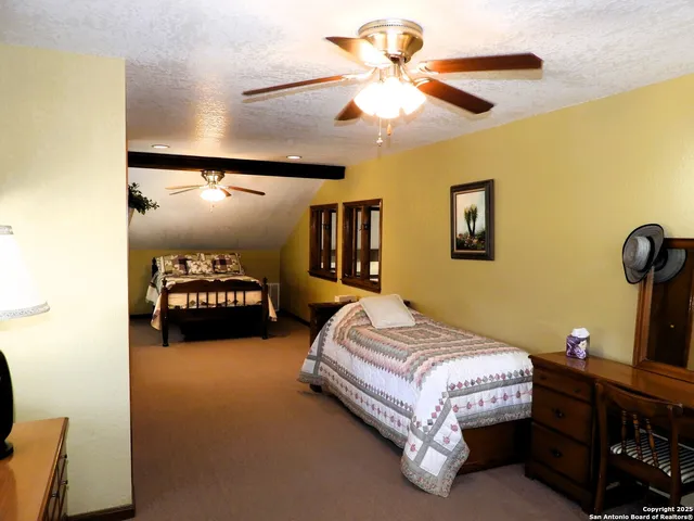 a spacious bedroom with a bed and dresser
