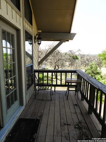 a view of a balcony with furniture and wooden floor