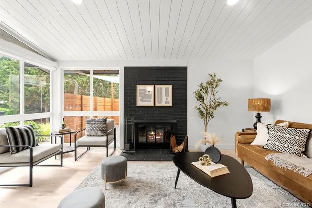 a living room with furniture a fireplace and a large window