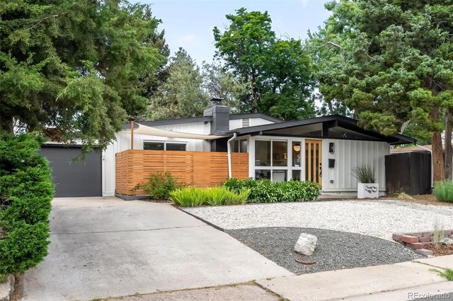 a front view of house with yard and trees around