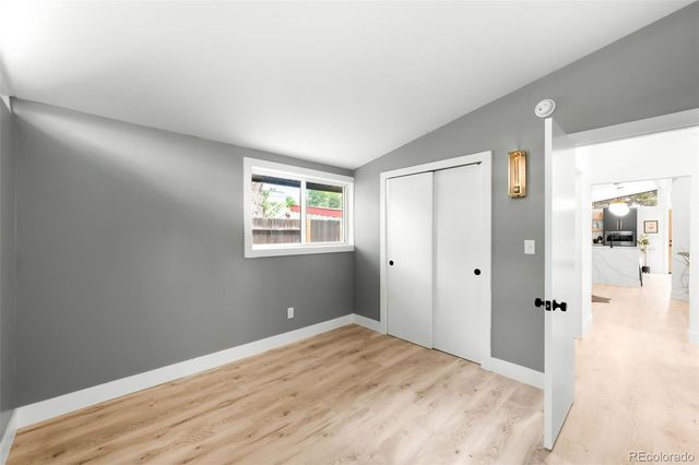 a view of a hallway with wooden floor and closet area