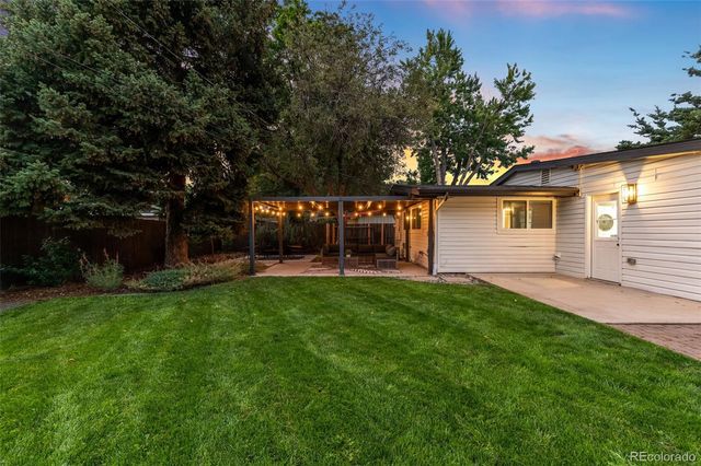 a view of a house with backyard and sitting area