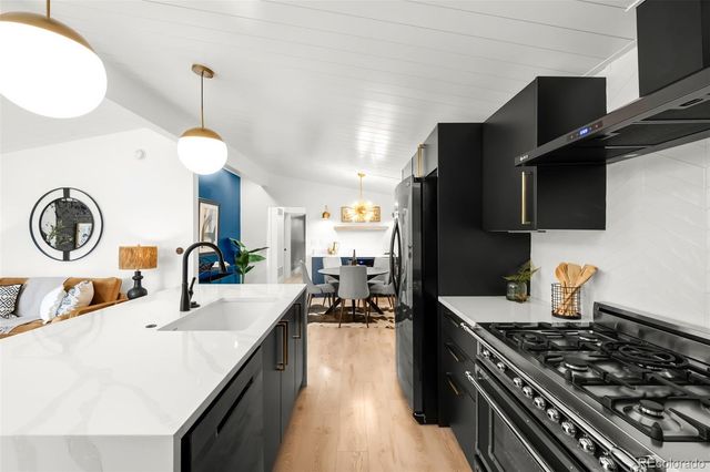 a kitchen with a sink a stove and a wooden floor