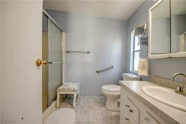a bathroom with a granite countertop toilet a sink and a mirror