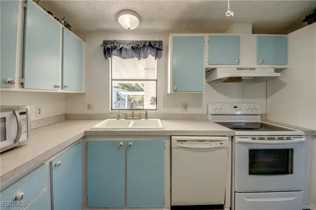 a kitchen with a sink stove and cabinets
