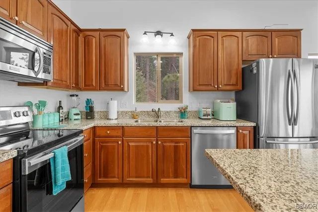 a kitchen with stainless steel appliances granite countertop a stove a sink dishwasher and a refrigerator