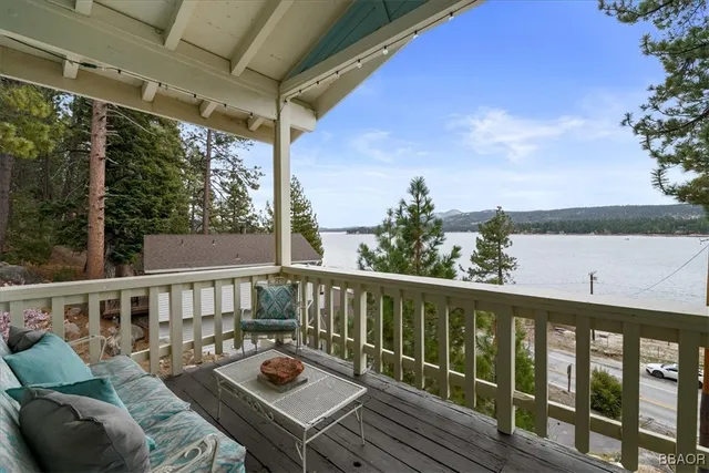 a view of a balcony with wooden floor and outdoor seating