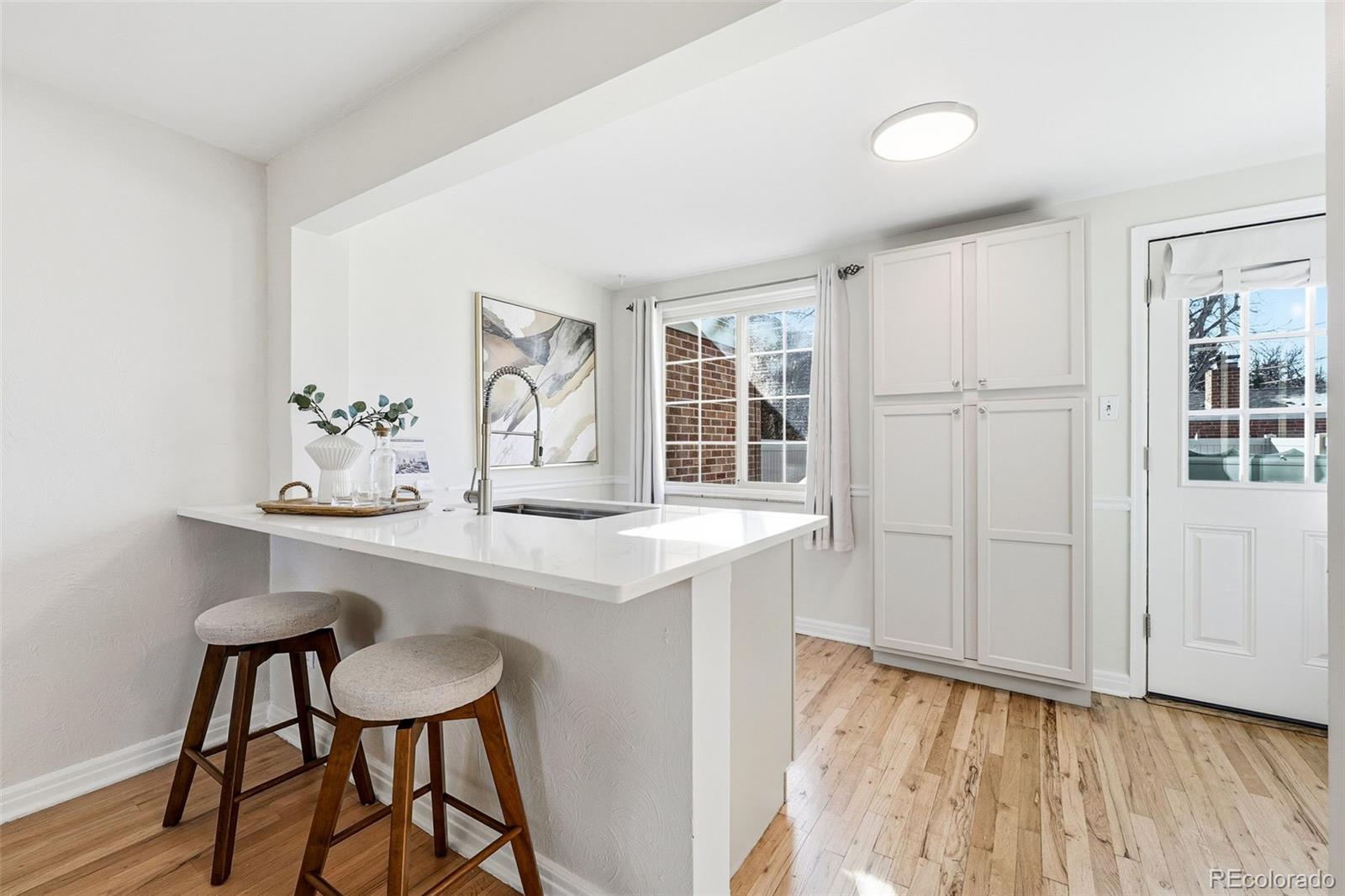 781 Forest Street Denver, CO 80220 - Photo 5 of 19 a kitchen with a sink cabinets and wooden floor