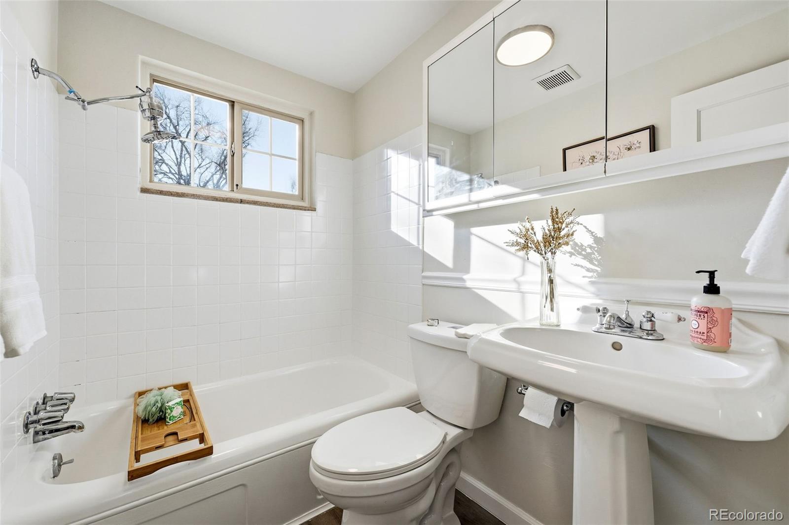 781 Forest Street Denver, CO 80220 - Photo 9 of 19 a bathroom with a sink a toilet and shower curtain