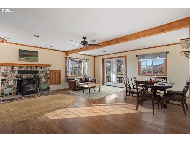 a kitchen with stainless steel appliances granite countertop a refrigerator a sink a stove and white cabinets with wooden floor