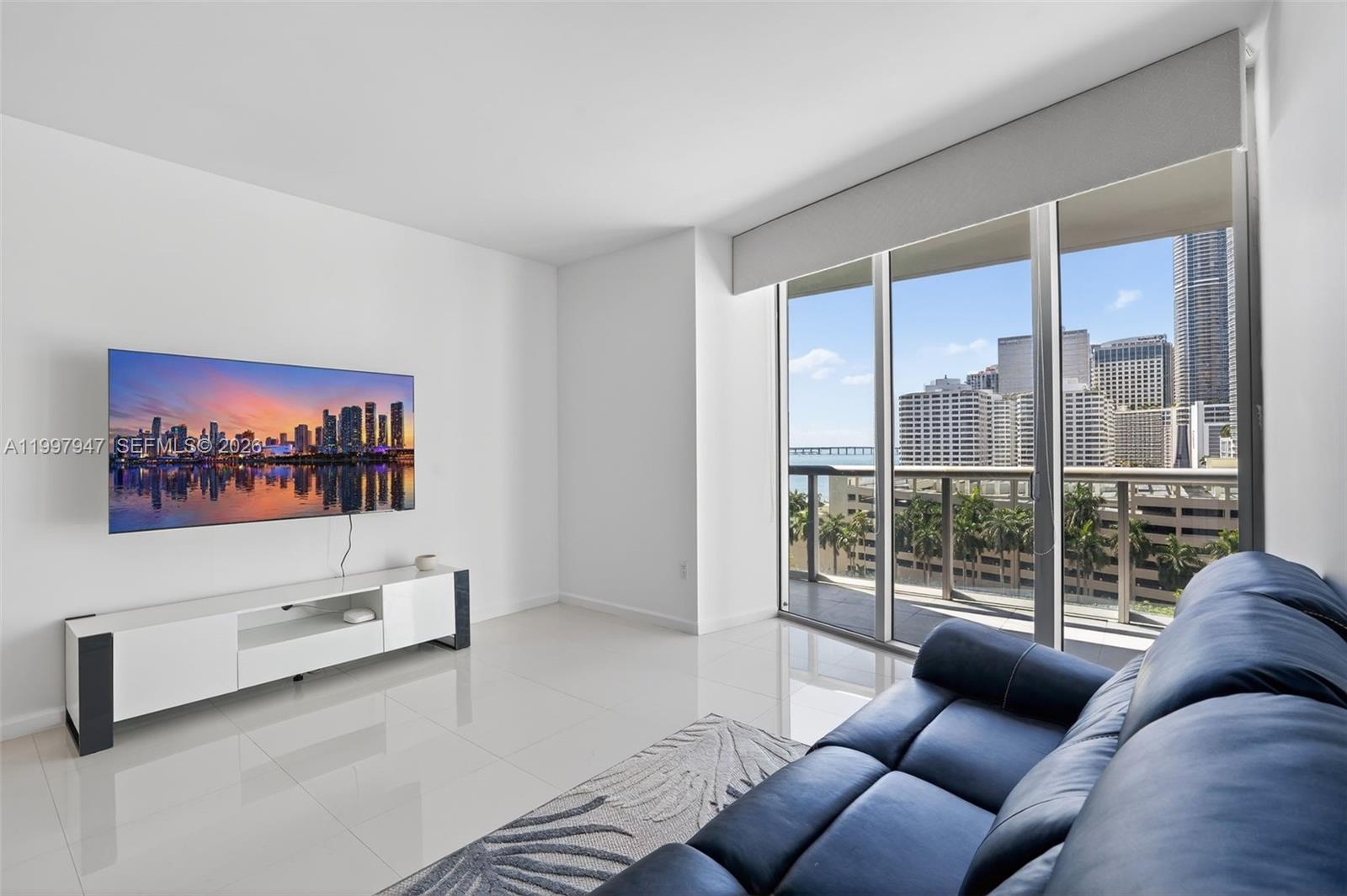495 Brickell Avenue, Unit 1007 Miami, FL 33131 - Photo 4 of 17 a living room with furniture a window and a flat screen tv