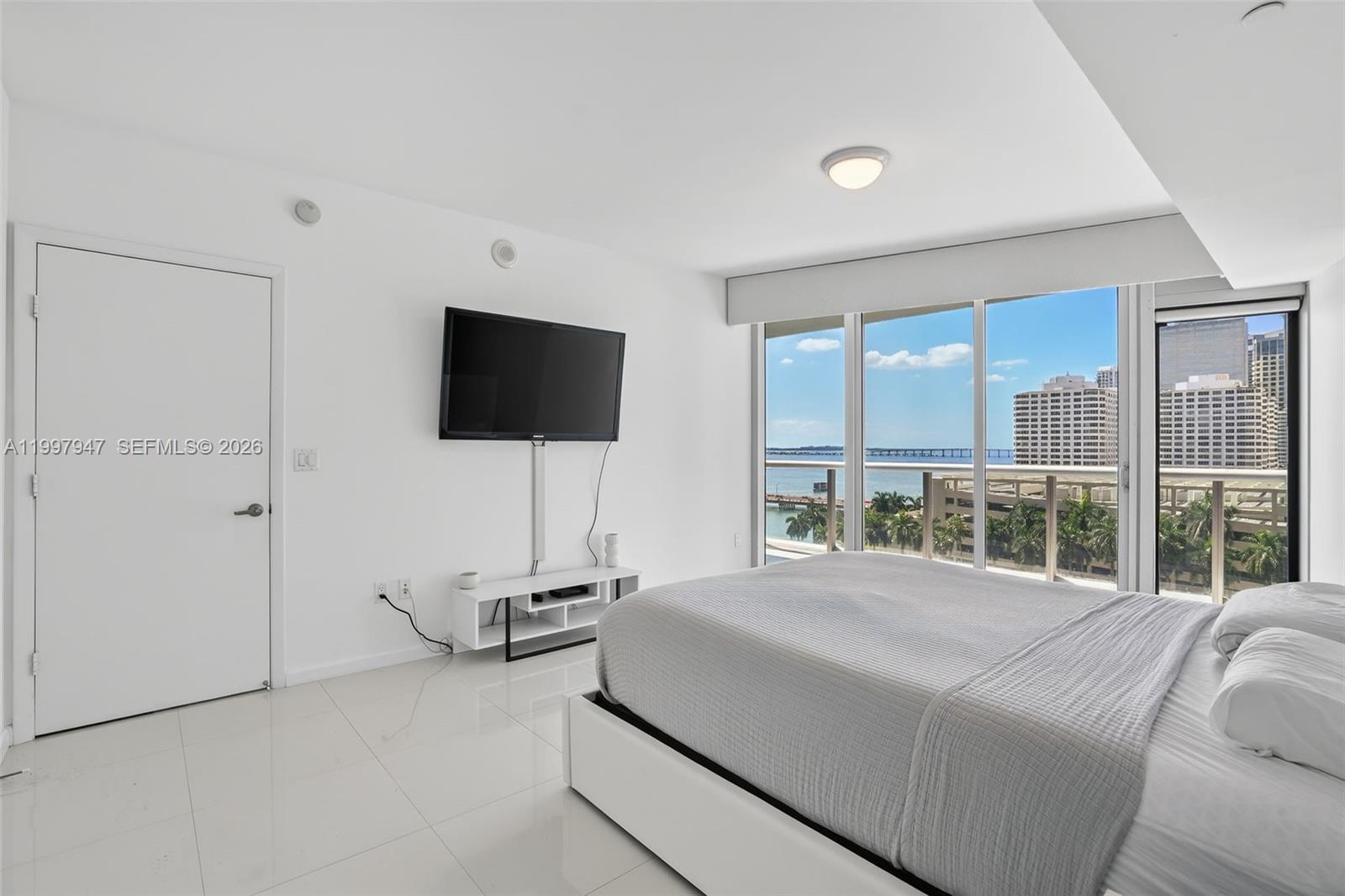 495 Brickell Avenue, Unit 1007 Miami, FL 33131 - Photo 6 of 17 a bedroom with a bed and large window