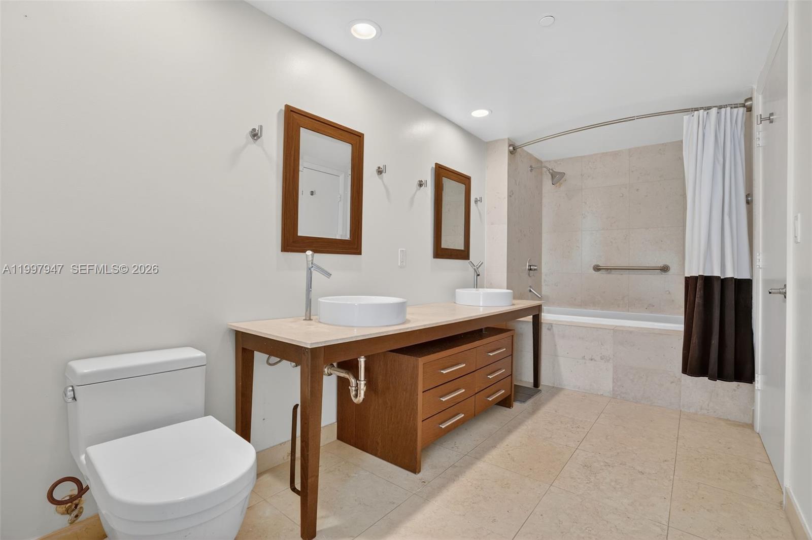 495 Brickell Avenue, Unit 1007 Miami, FL 33131 - Photo 7 of 17 a bathroom with a toilet a sink and mirror