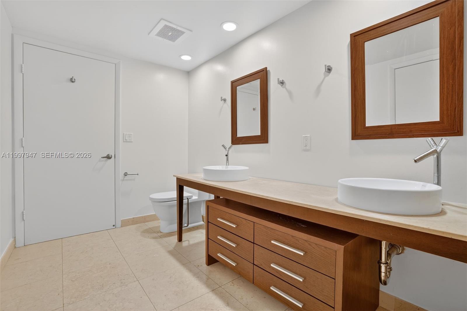 495 Brickell Avenue, Unit 1007 Miami, FL 33131 - Photo 8 of 17 a bathroom with a sink a light fixture and a mirror