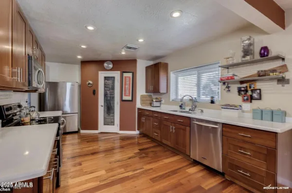 a open kitchen with stainless steel appliances granite countertop a sink dishwasher stove and refrigerator