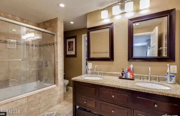 a bathroom with a granite countertop sink mirror and bathtub