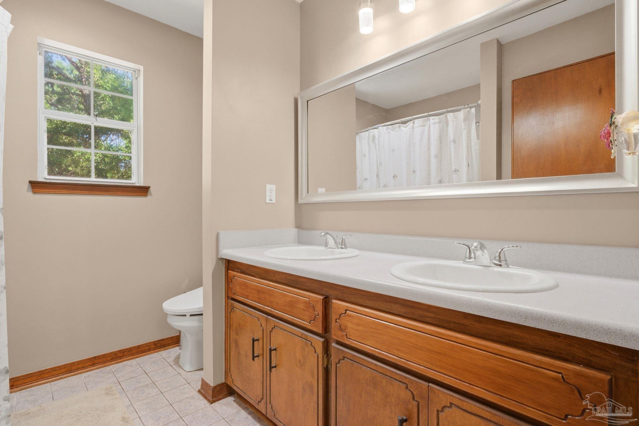 6870 Martin Road Milton, FL 32570 - Photo 22 of 48 a bathroom with a sink a toilet and a window