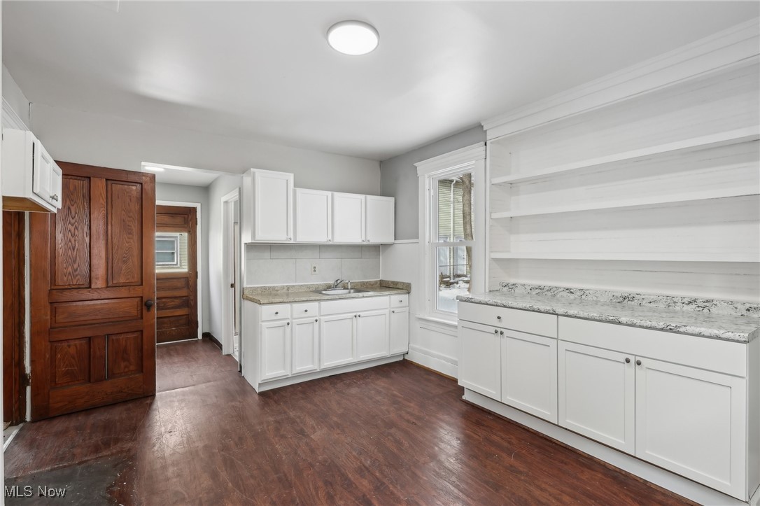 73 East York Street Akron, OH 44310 - Photo 15 of 36 Kitchen with white cabinetry, light stone countertops, sink, and backsplash