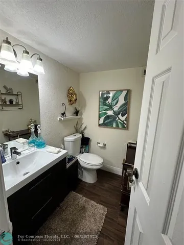 a bathroom with a sink mirror toilet and next to a window
