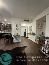 a living room with chairs and couches with wooden floor