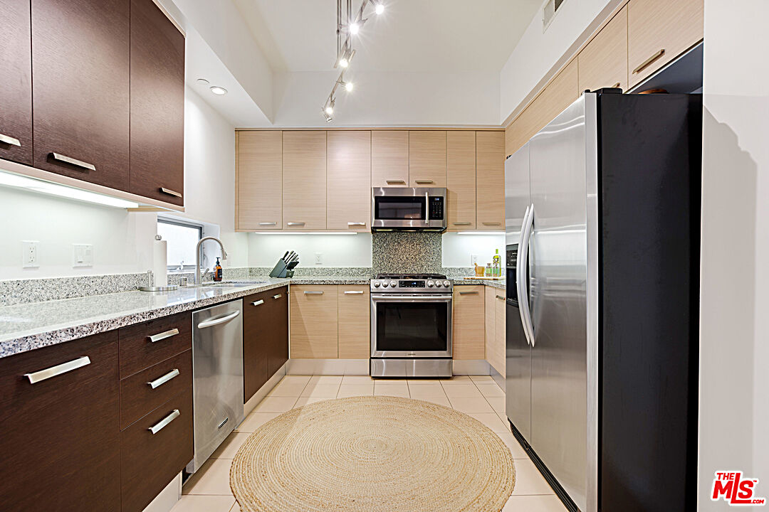 12411 Pacific Avenue, Unit 205 Los Angeles, CA 90066 - Photo 6 of 21 a kitchen with granite countertop a refrigerator stove and sink