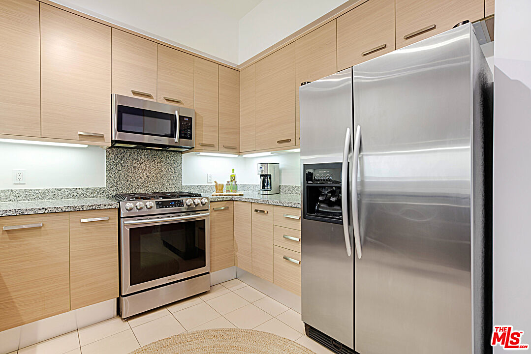 12411 Pacific Avenue, Unit 205 Los Angeles, CA 90066 - Photo 8 of 21 a kitchen with stainless steel appliances granite countertop a refrigerator a stove and a sink with wooden floor