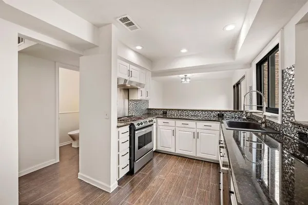 a kitchen with stainless steel appliances granite countertop a stove and a refrigerator