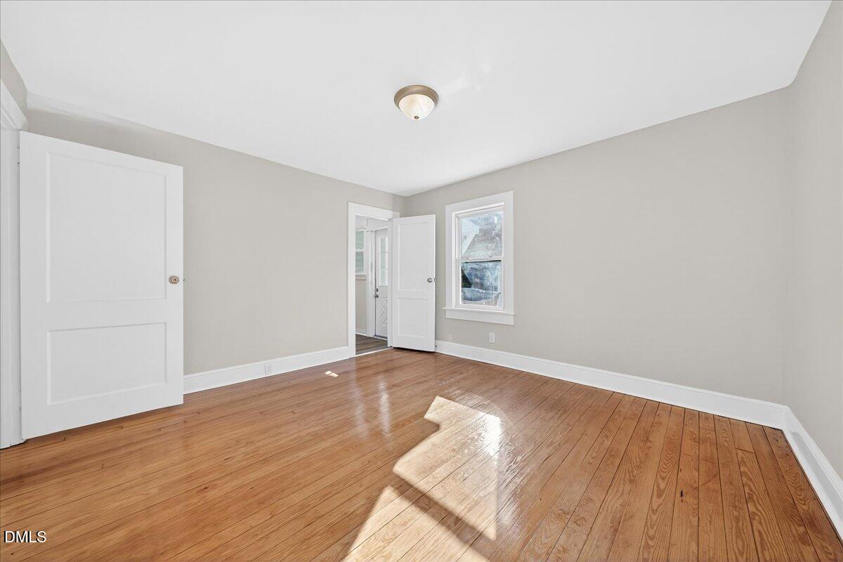 23 West Academy Street Wendell, NC 27591 - Photo 18 of 31 a view of an empty room with wooden floor and a window