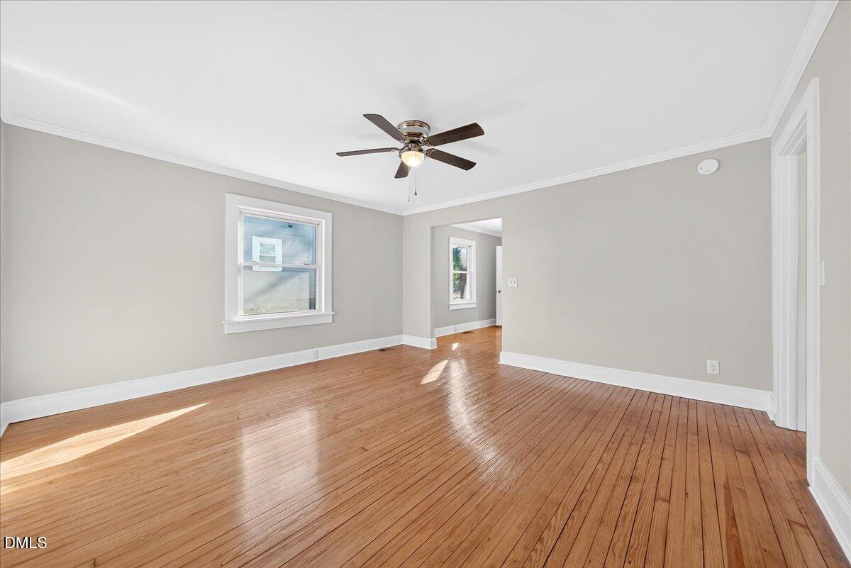 23 West Academy Street Wendell, NC 27591 - Photo 5 of 31 an empty room with wooden floor and windows